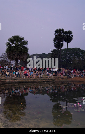 Vertikale Ansicht von Touristen beisammen sitzen rund um einen See, beobachten den Sonnenaufgang über Prasat Angkor Wat. Stockfoto