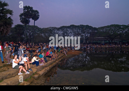 Horizontale Ansicht von Touristen beisammen sitzen rund um einen See, beobachten den Sonnenaufgang über Prasat Angkor Wat. Stockfoto