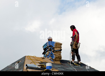 Arbeiter auf dem Dach installieren Schindeln Stockfoto