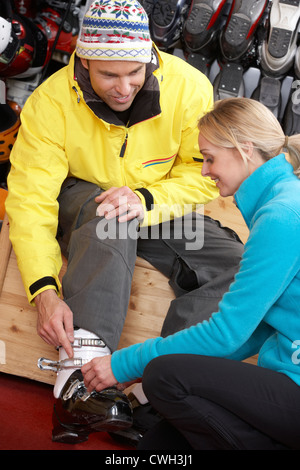 Sales Assistant hilft Mann, versuchen auf Skischuhe im Verleih Shop Stockfoto