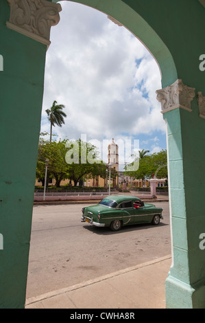 Eine alte antike 1950er Jahre Oldtimer und Kirche Iglesia Mayor de San Juan Bautista aus dem Torbogen in Remedios, Kuba. Stockfoto