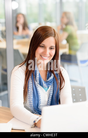 Studentin, die lächelnd Typisierung Laptop am Gymnasium Arbeitszimmer Stockfoto