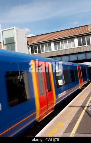 Wagen eines Passagiers Zug in South West Trains Lackierung Clapham Junction Durchgangsbahnhof, England zu beschleunigen. Stockfoto