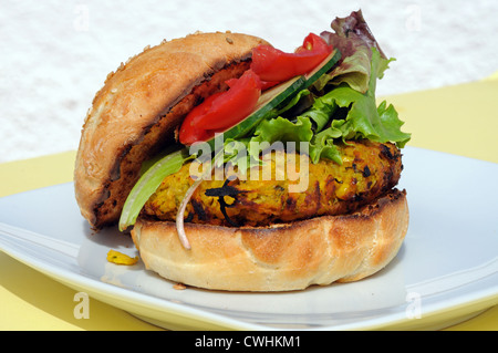 Vegetarische Kichererbsen, Mais und Karotten-Burger mit Salat in einem Sesam Brötchen, UK. Stockfoto