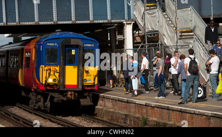 Passagiere warten, als eine Klasse 455 Bahnhof in South West Trains Livree Ansätze Clapham Junction, England. Stockfoto