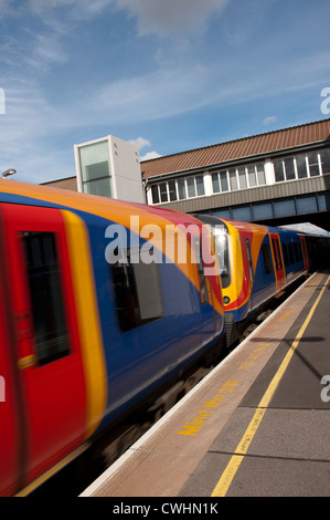 Wagen eines Passagiers Zug in South West Trains Lackierung Clapham Junction Durchgangsbahnhof, England zu beschleunigen. Stockfoto