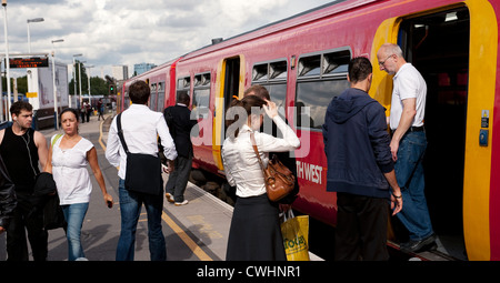 Passagiere erhalten und verlassen einen Passagier Zug in South West Trains Lackierung am Bahnhof Clapham, England. Stockfoto