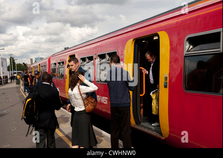 Passagiere erhalten und verlassen einen Passagier Zug in South West Trains Lackierung am Bahnhof Clapham, England. Stockfoto