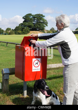 English Springer Spaniel mit Eigentümer setzen Beutel der Hundehaufen in den Papierkorb, indem Sie Felder auf tägliche Routine Spaziergang in der Stadt park England Großbritannien Großbritannien Stockfoto