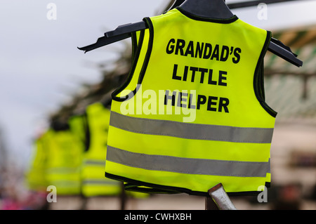 Warnwesten mit Slogan "Opas kleine Helfer" zum Verkauf an einem Marktstand Stockfoto