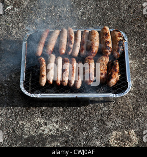 Würste Kochen auf einem Einweg-Grill, Cornwall, England, Vereinigtes Königreich. Stockfoto