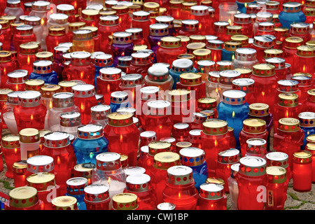 Ein Großteil der beleuchteten votive Kerzen leuchtet auf eine schwere Laterne Stockfoto