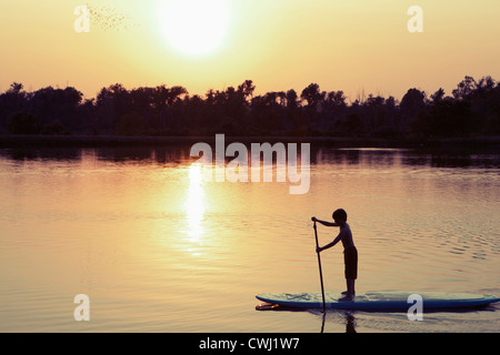 Kaukasische junge auf Paddleboard auf See Stockfoto