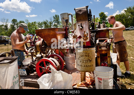 Männer, die Mais schälen Maschine an einem antiken Gas und Dampfmaschine in Betrieb zeigen bei Fort Hunter, Erie-Kanal Upstate New York Stockfoto