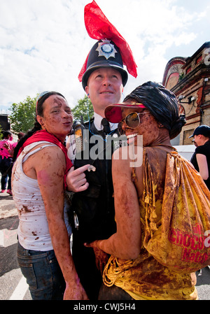 Die Teilnehmer spielen und tanzen mit der Polizei am jährlichen Notting Hill Karneval 2012 Stockfoto