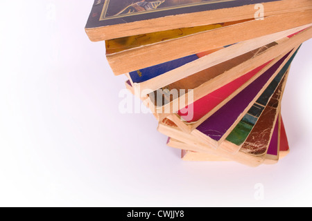 Stapel von bunten alten Taschenbuch Bücher in Spirale Stack auf weißem Hintergrund Stockfoto