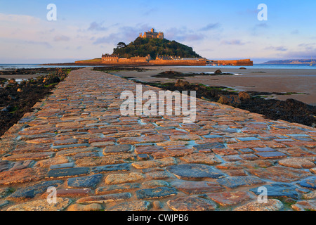 Die gepflasterten Damm führt zu St Michaels Mount in Cornwall, bei Sonnenaufgang auf einem Ebbe genommen. Stockfoto