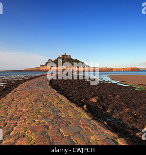 Sonnenaufgang am St Michaels Mount in Cornwall, bei Ebbe offenbart den gepflasterten Damm führt bis hin zur Insel genommen. Stockfoto