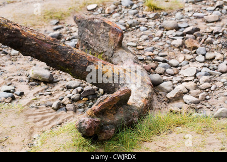 Alten rostigen Anker auf einem britischen Strand. Stockfoto