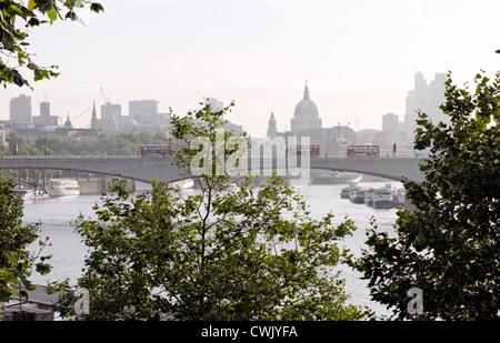 London, UK. Waterloo Bridge, St. Pauls Cathedral, Themse und London Skyline mit grünen Bäumen und roten Busse Stockfoto