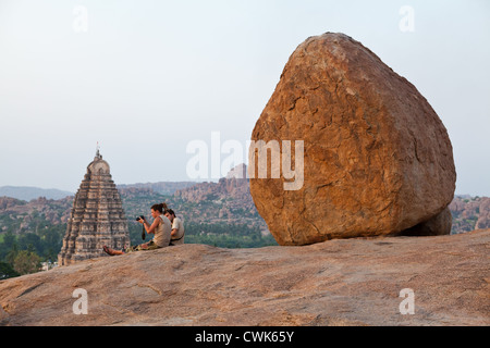 Touristen, die den Sonnenuntergang auf dem Hemakuta Hill in Hampi Stockfoto