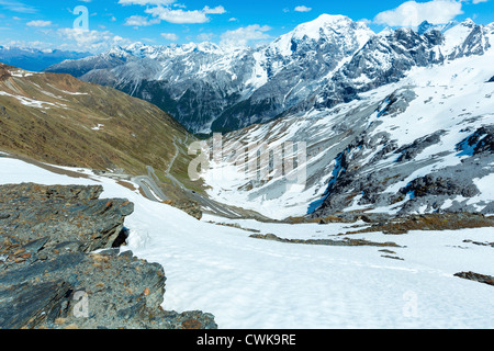 Sommer-Stilfser Joch mit Alpenstraße und Schnee am Hang (Italien) Stockfoto