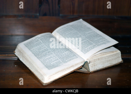 Einer alten Ausgabe der Heiligen Schrift liegen offen auf einem hölzernen Schreibtisch in einer Kirche Stockfoto