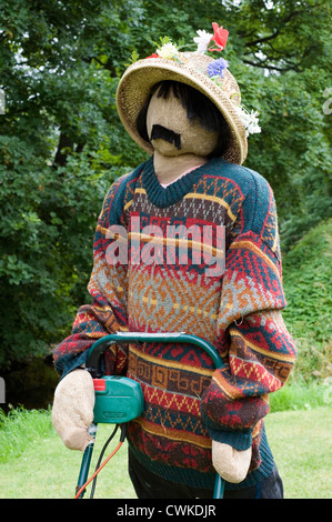 Vogelscheuche Kettlewell Festival Darstellung eines Mannes mit Rasenmäher mäht den Rasen Stockfoto