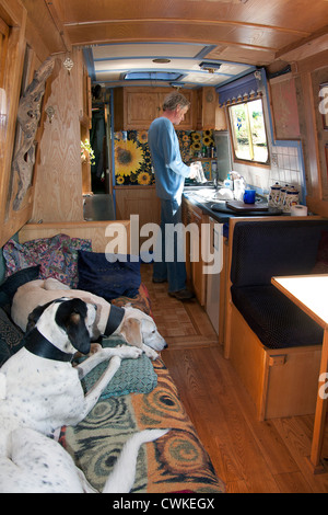 ein Mann und lebe auf Kanalboot mit zwei Rettungshunden Stockfoto