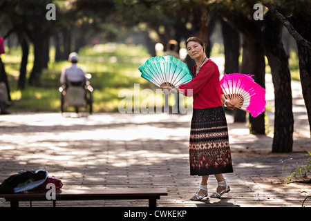 Eine ältere Chinesin Praktiken Tai Chi Fan Tanz Kampfkunst trainieren Sie am frühen Morgen im Tempel des Himmels Park Stockfoto