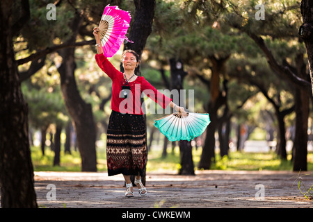 Eine ältere Chinesin Praktiken Tai Chi Fan Tanz Kampfkunst trainieren Sie am frühen Morgen im Tempel des Himmels Park Stockfoto