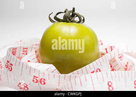 Studioaufnahme von grünen Tomaten und ein Maßband auf weißen Hintergrund Stockfoto