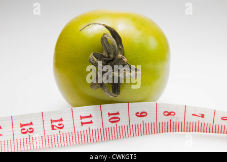 Studioaufnahme von grünen Tomaten und ein Maßband auf weißen Hintergrund Stockfoto