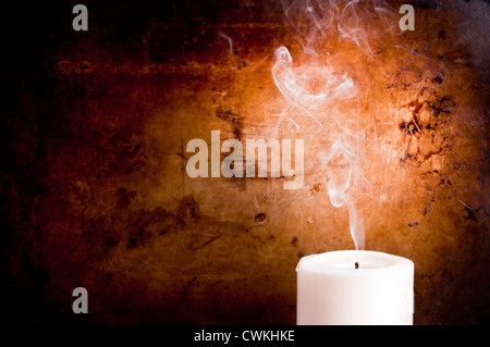Routen in glatten Linien aus einer ausgeblasen Kerze mit einem Vintage-Hintergrund zu rauchen Stockfoto