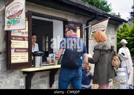 Kauf von Erfrischungen im kleinen Laden für seine Familie während der Vogelscheuche Festival in Kettlewell Mann Stockfoto