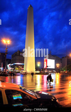 Blick auf Obelisk Denkmal und Autos, an regnerischen Nacht mit Fahrzeug-Leuchten von feuchten Boden reflektiert. Buenos Aires, Argentinien Stockfoto