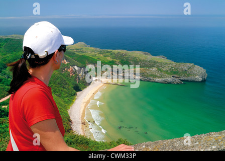 Spanien, Asturien: Frau auf der Suche nach La Ballota vom Strand Punkt La Borizo in Llanes anzeigen Stockfoto