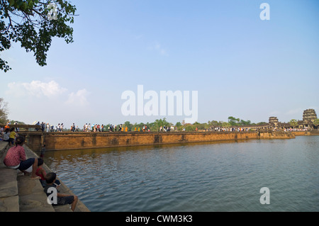 Horizontale Ansicht von Touristen zu sitzen und zu Fuß entlang der wichtigsten Damm an der westlichen Gopura, der Einstieg in Angkor Wat. Stockfoto