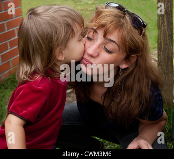 Attraktive polnische Mutter immer einen dicken Kuss von ihrer kleinen Tochter Alter 2 und 32. Zawady Zentralpolen Stockfoto