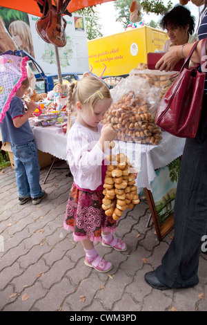 Tochter hält Brot Halsketten () in einem polnischen Markt (Rynek) gekauft. Spala Zentralpolen Stockfoto