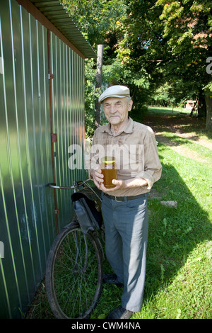 Polnische Imker, Honig-Landwirt oder Imker halten Glas Honig auf seinem Fahrrad Tour. Zawady Zentralpolen Stockfoto