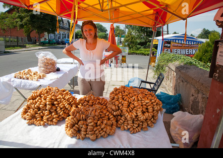 Ansprechende Kiosk Frau verkaufen Brot Halsketten () am Sonntag Rynek. Rzeczyca Zentralpolen Stockfoto