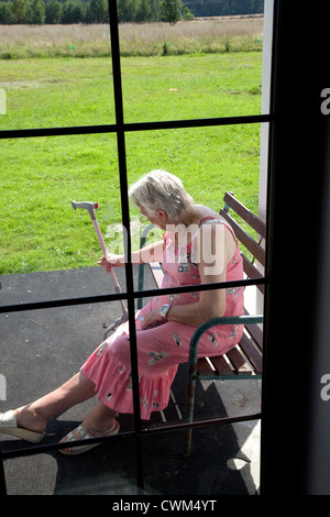 Ältere Polin Alter von 86 Jahren sitzen allein auf ihrer Veranda mit Blick auf den Hof. Zawady Zentralpolen Stockfoto