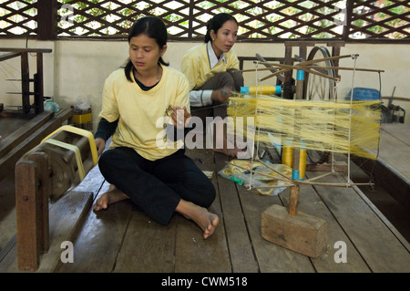 Horizontale Nahaufnahme von Frauen Spinnen Seide in Threads bereit für den Einsatz auf einem Webstuhl in einer Seidenfabrik produzieren in Kambodscha. Stockfoto