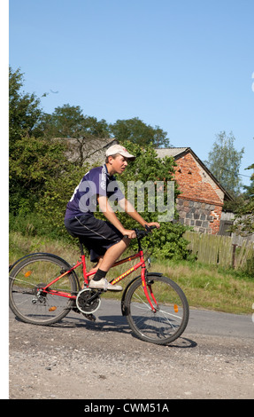 Polnische teenboy Reiten Fahrrad entlang ländliches Dorf Gasse. Mala Wola Zentralpolen Stockfoto