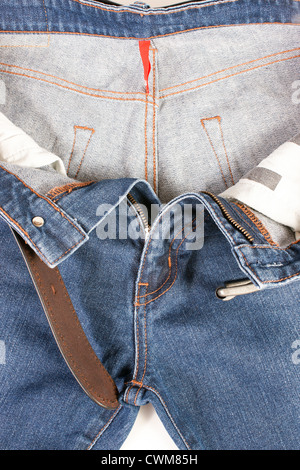 Blaue Jeans mit braunen Ledergürtel auf weißem Hintergrund Stockfoto