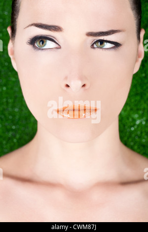 Closeup Portrait einer schönen böse Frau mit glänzenden Lippen wegsehen auf grünem Hintergrund Stockfoto