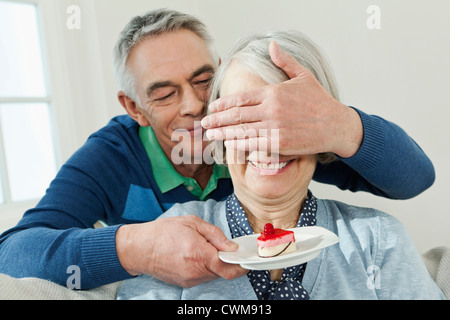 Deutschland, Berlin, Mann überraschend Frau mit Kuchen serviert Stockfoto