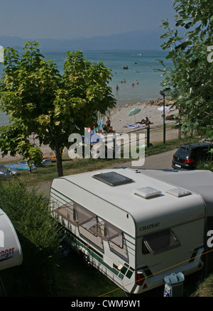 Wohnwagen geparkt neben dem Strand am Gardasee, Camping Lido, Pacengo, Italien, an einem heißen Sommertag im August Stockfoto