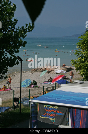 Wohnwagen geparkt neben dem Strand am Gardasee, Camping Lido, Pacengo, Italien, an einem heißen Sommertag im August Stockfoto